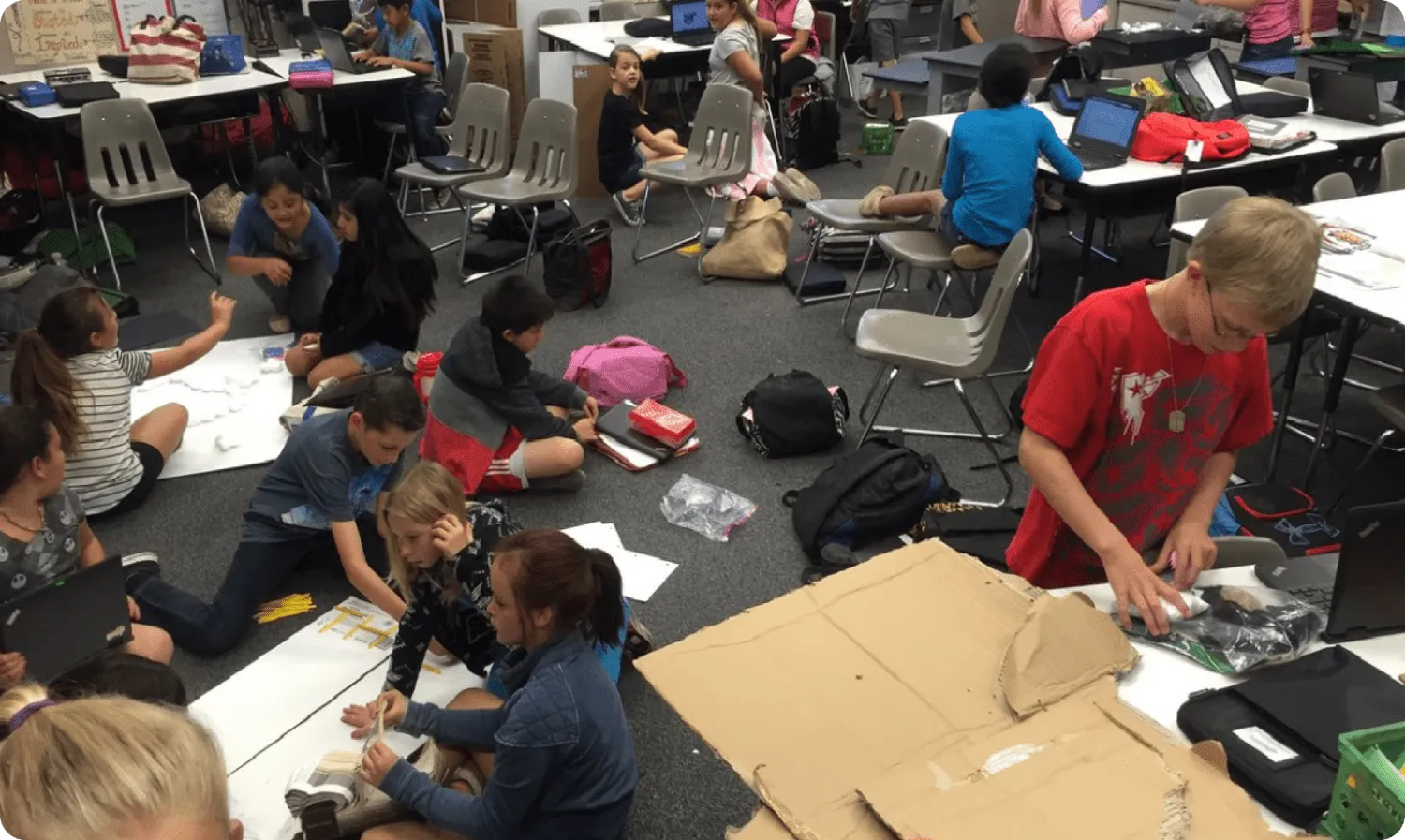 A classroom of students working on Qweebi projects on their laptops.